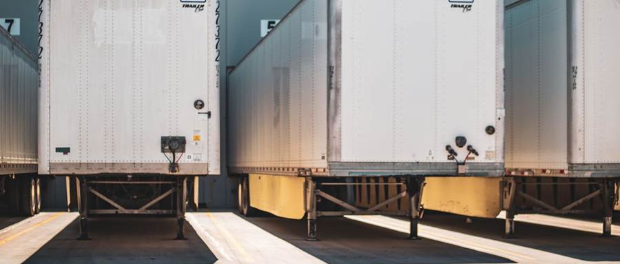 White trailers backed into a freight dock